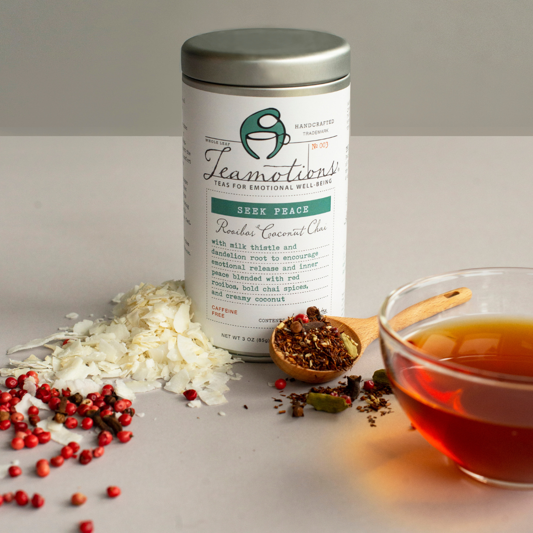 Tin of Teamotions tea with loose tea, coconut flakes, and a cup of tea.