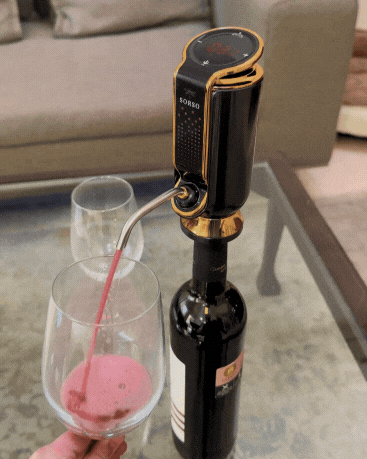 Wine being poured into a glass using an electric wine aerator.