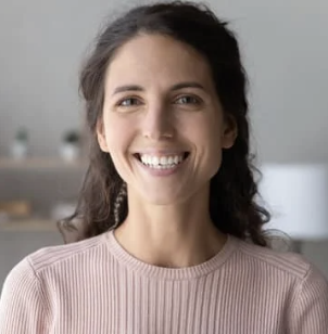 Smiling person with long dark hair, wearing a ribbed sweater.