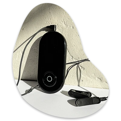Black electronic device with cables on a white surface.
