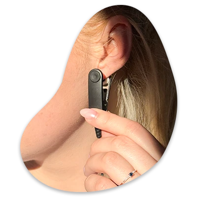 Person holding a black earbud near their ear.