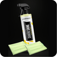 A spray bottle of Diamond Shine glass cleaner with two light green microfiber towels against a black background.