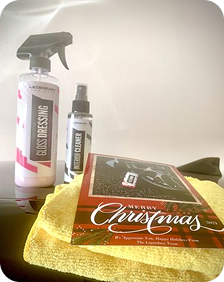Cleaning products with a Christmas card and yellow cloth on a surface.