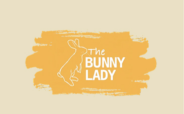 The logo for 'The Bunny Lady', featuring a white outline of a rabbit on a yellow brushstroke.