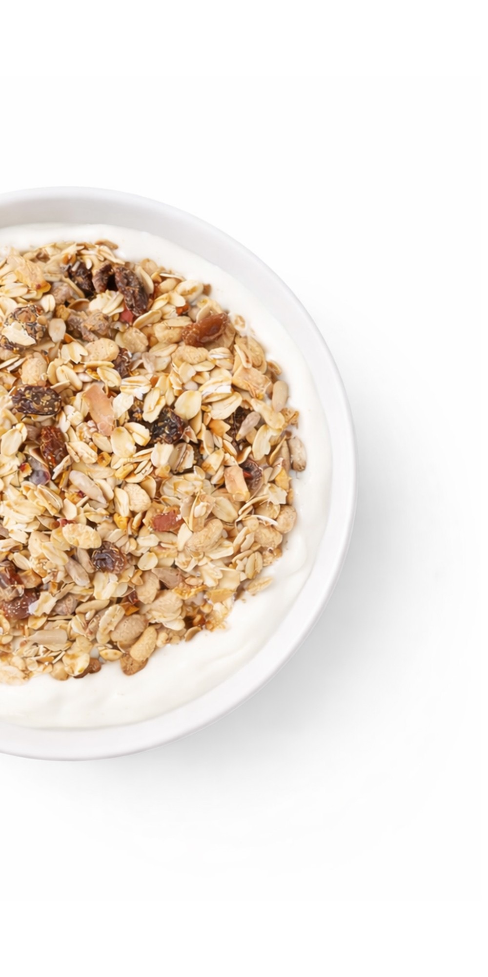 An overhead shot of a white bowl of yogurt topped with granola, raisins, and nuts.