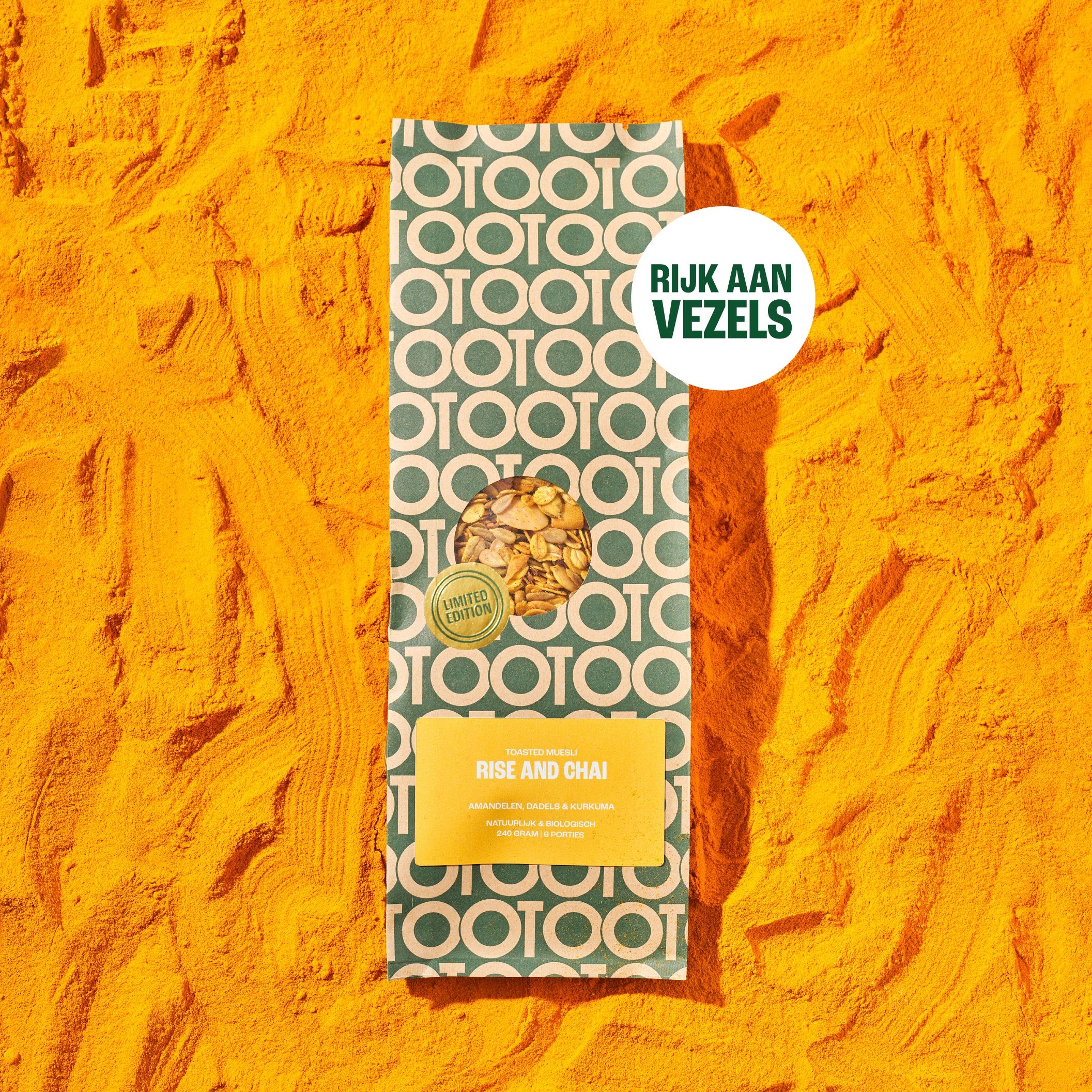A bag of Rise and Chai toasted muesli lying on a bed of bright yellow turmeric powder.