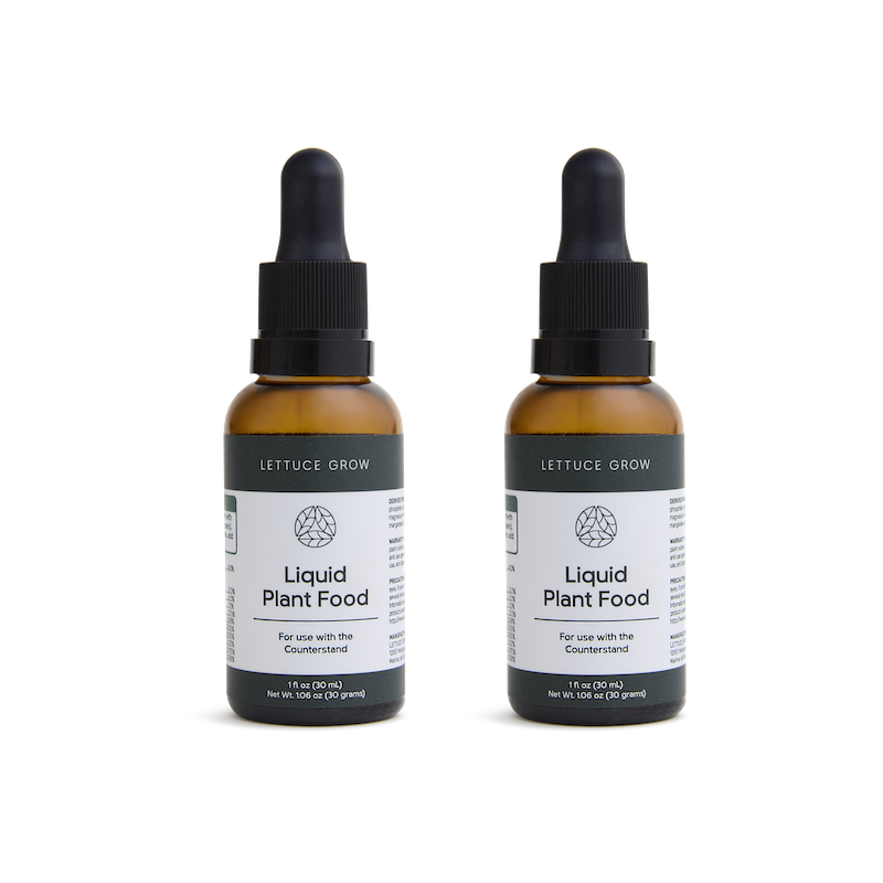 Two bottles of liquid plant food with black droppers.