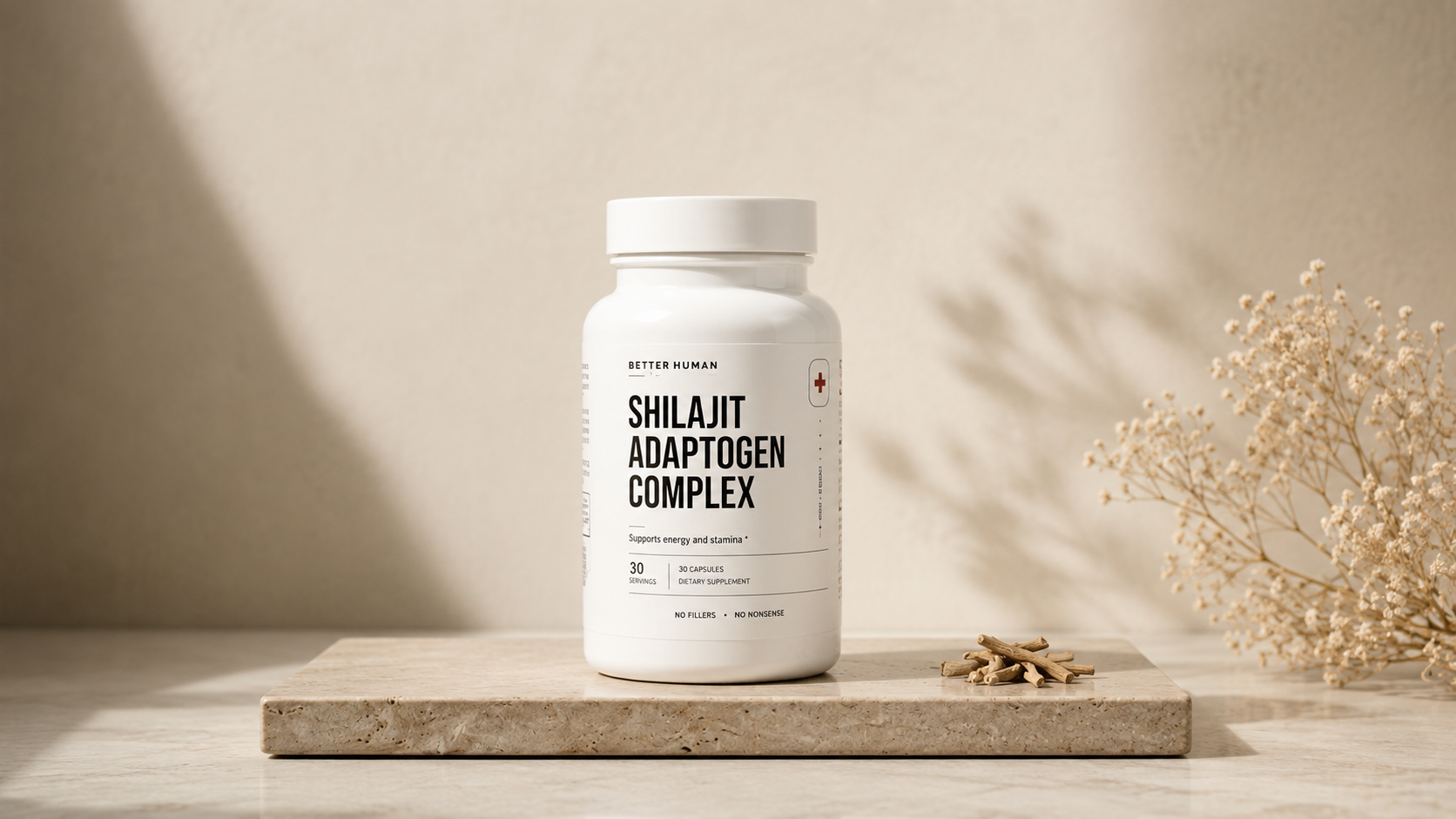 A white bottle of Better Human Shilajit Adaptogen Complex on a stone slab with dried botanicals.