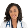 A headshot of a smiling woman wearing a doctor's white coat with a stethoscope around her neck.