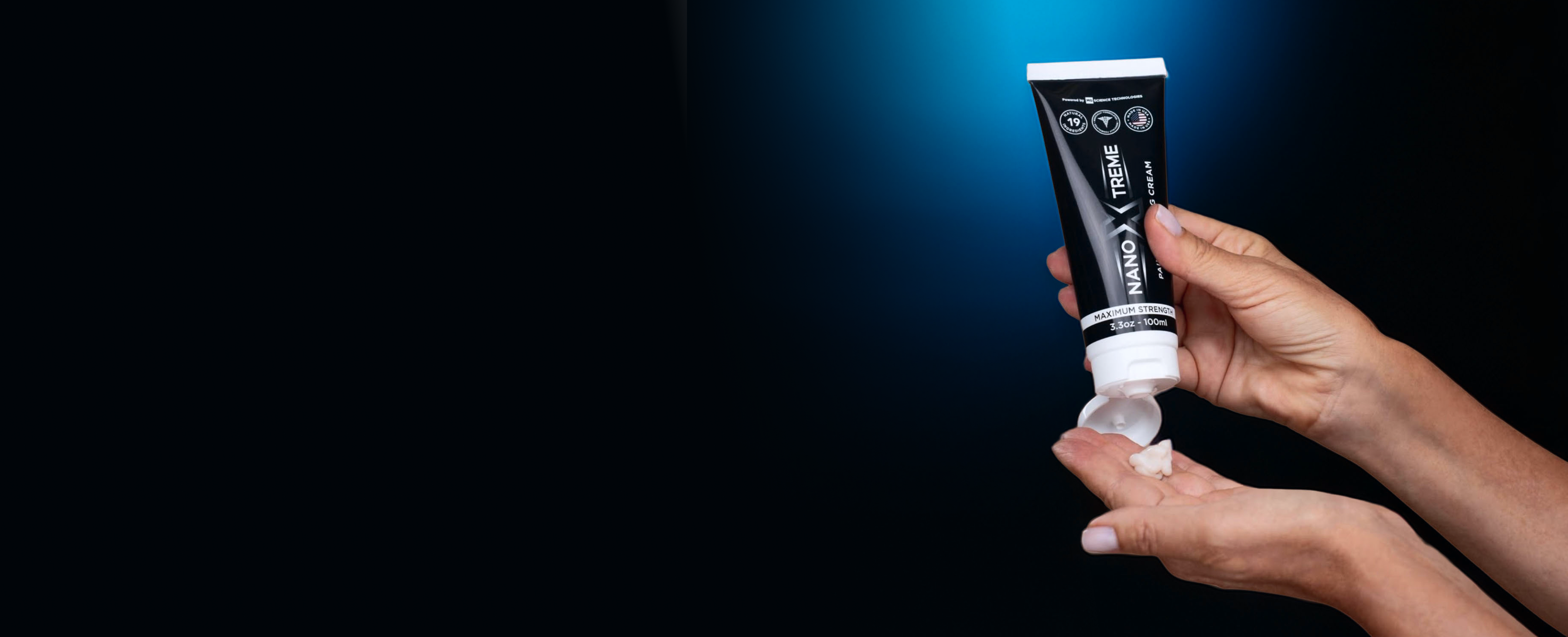 A person squeezes cream from a black tube of Nano Xtreme onto their hand.
