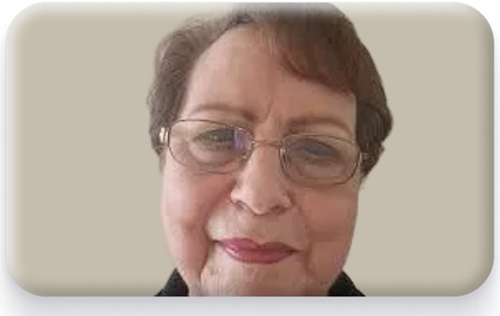 A person with glasses smiling against a neutral background.
