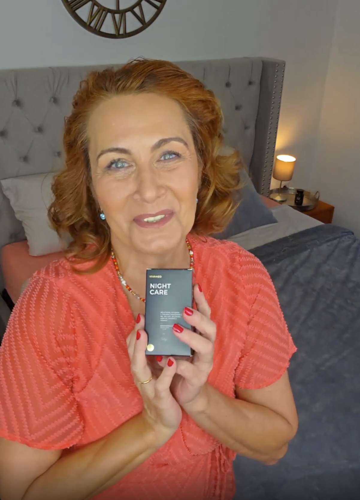 Person holding a black box labeled 'Night Care' in a bedroom.