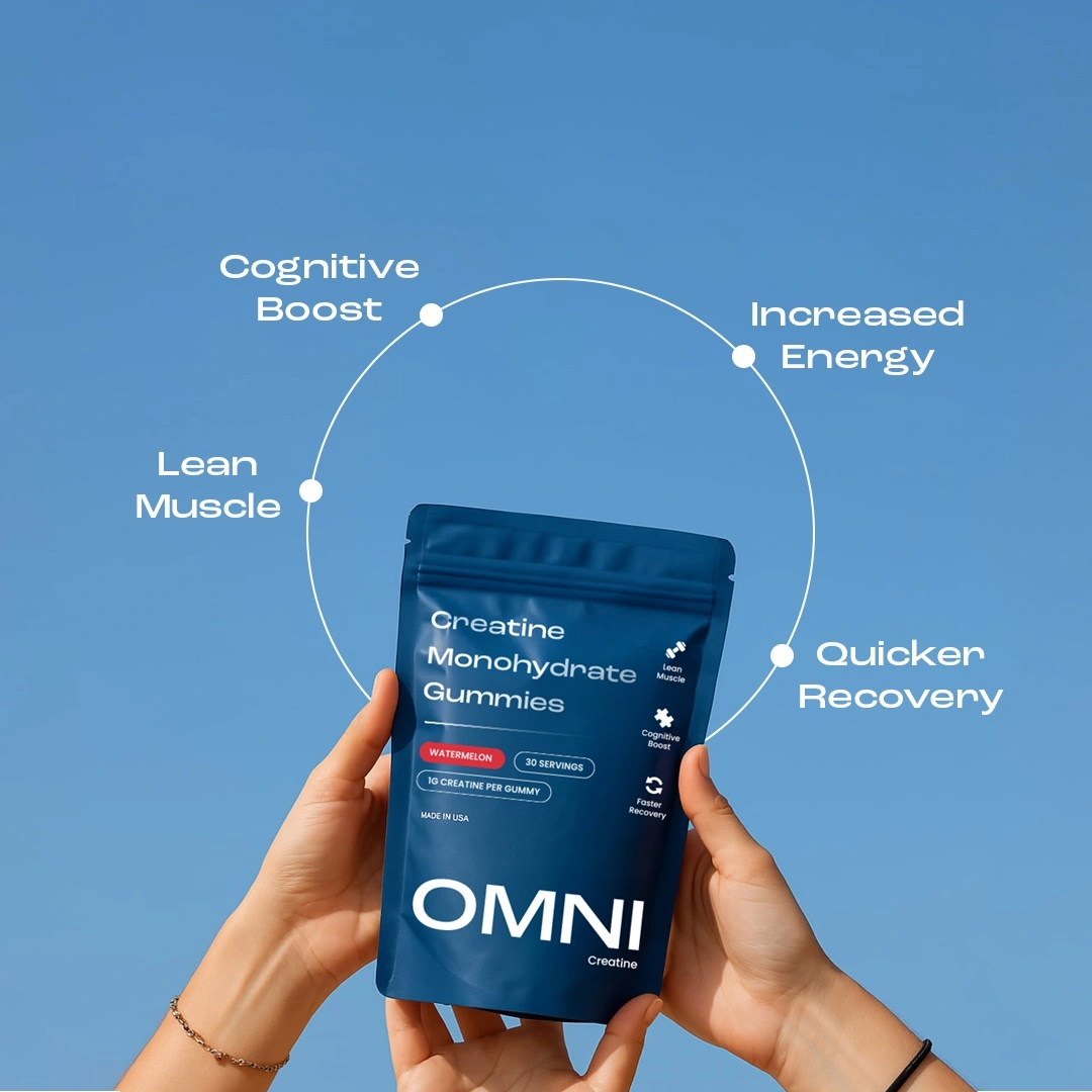 Hands holding a blue package of creatine monohydrate gummies against a blue sky.