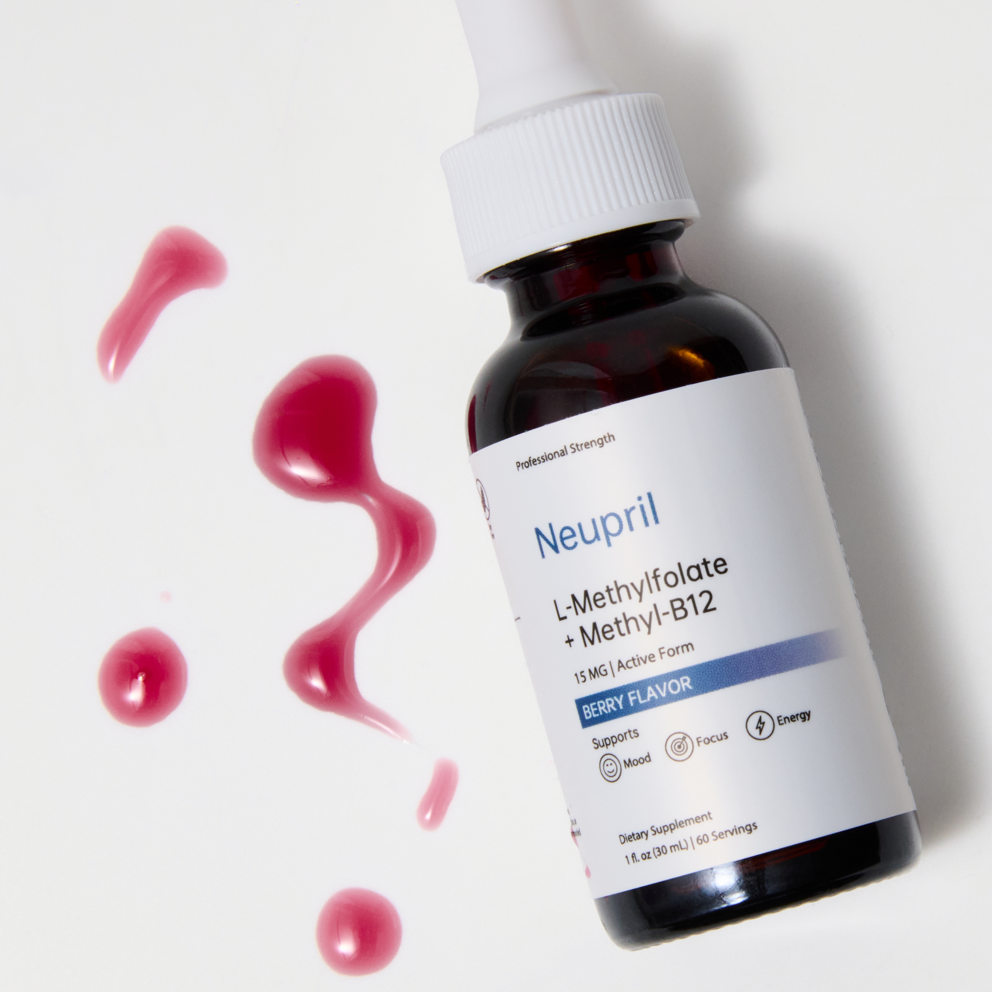 A bottle of Neupril L-Methylfolate + Methyl-B12 supplement lying on a white surface with bright berry-colored liquid drops around it, highlighting its berry flavor