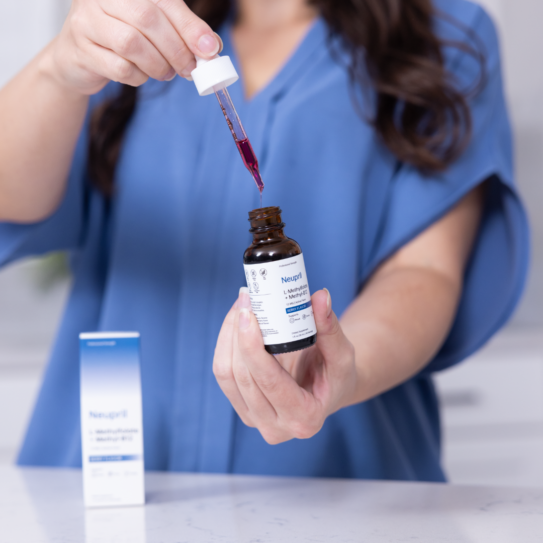 Person dispensing red methylfolate drops from a Neupril bottle.