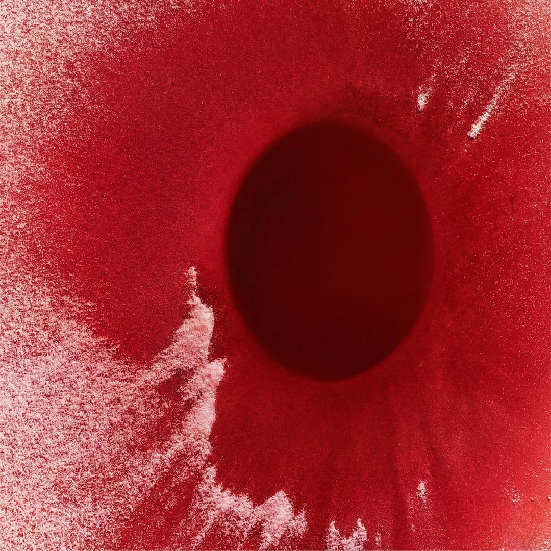 Red powdered nutrient surface with a darker center of liquid concentration