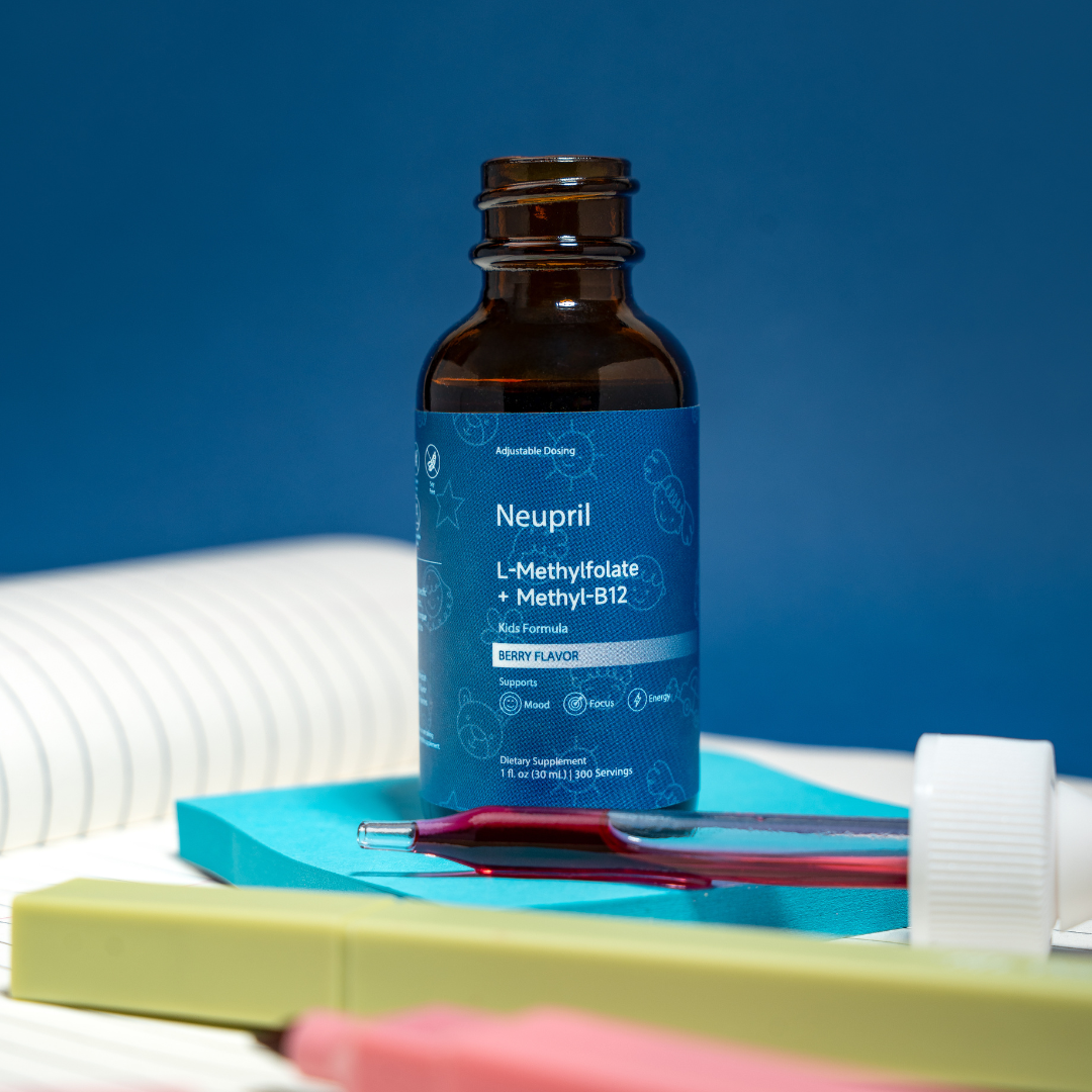 A clean overhead view of Neupril Professional Strength L-Methylfolate + Methyl-B12 liquid supplement, showing the amber glass dropper bottle and a flat box unfolded to reveal the Supplement Facts panel, ingredients, and directions. The set is framed by fresh raspberries and blueberries on a light blue background.