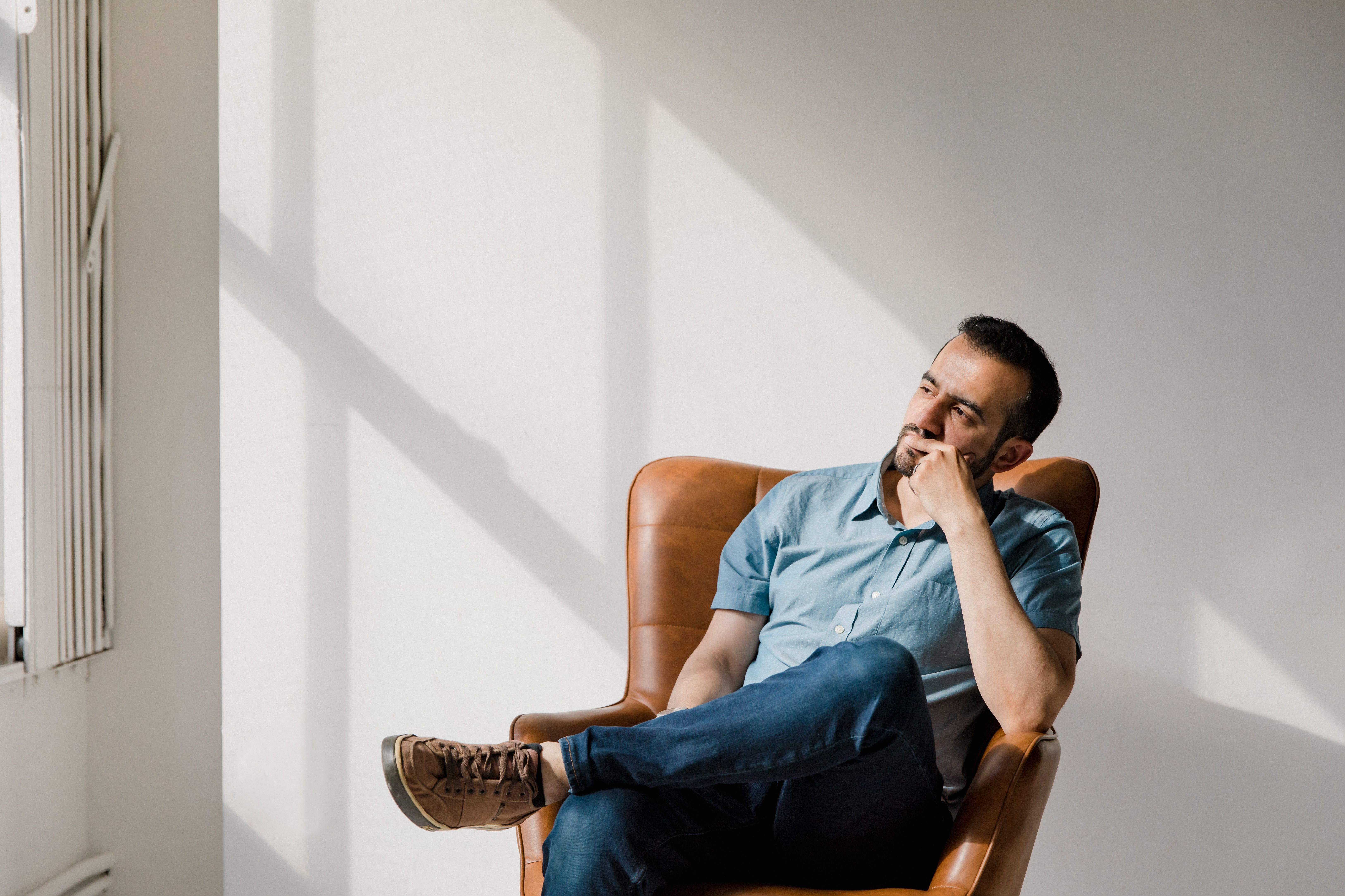 A man sitting in a chair, looking confused and needing brain supplements for focus