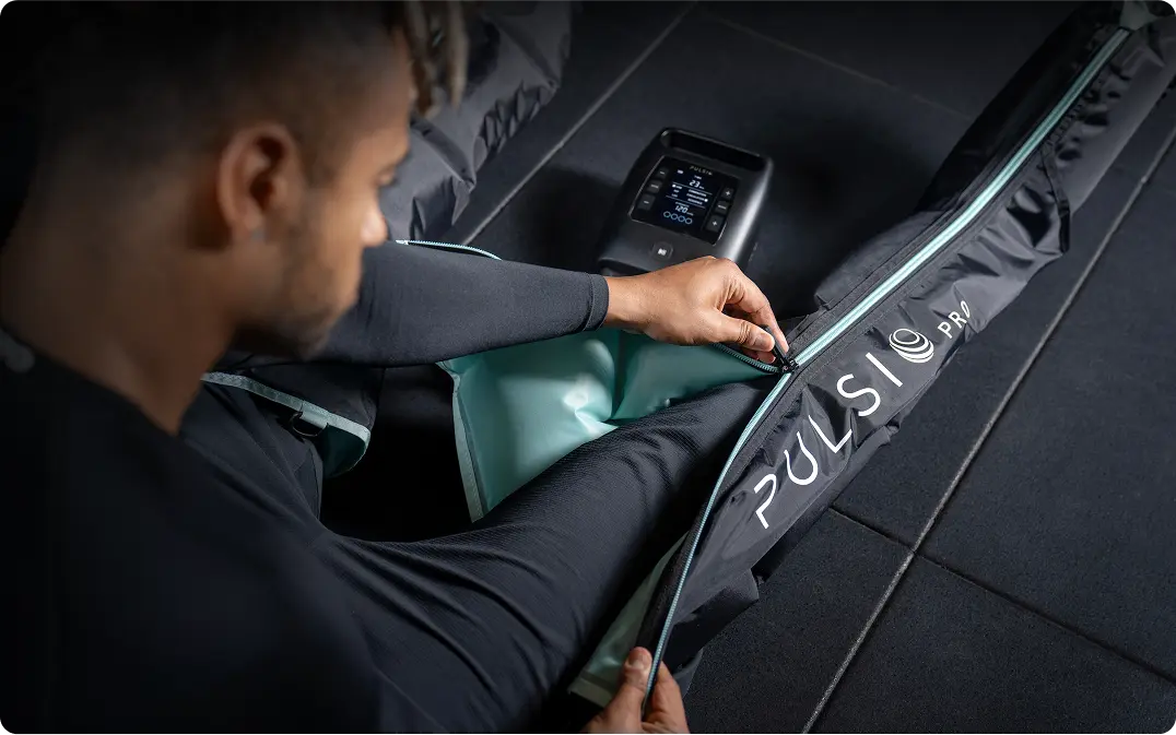 Person adjusting a compression sleeve with a control device nearby.