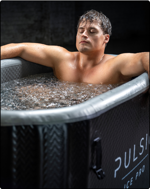Man relaxing in an ice bath with closed eyes and arms resting on the sides.