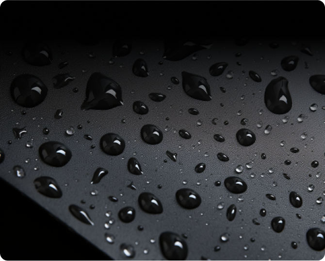 Close-up of water droplets on a dark, textured surface.