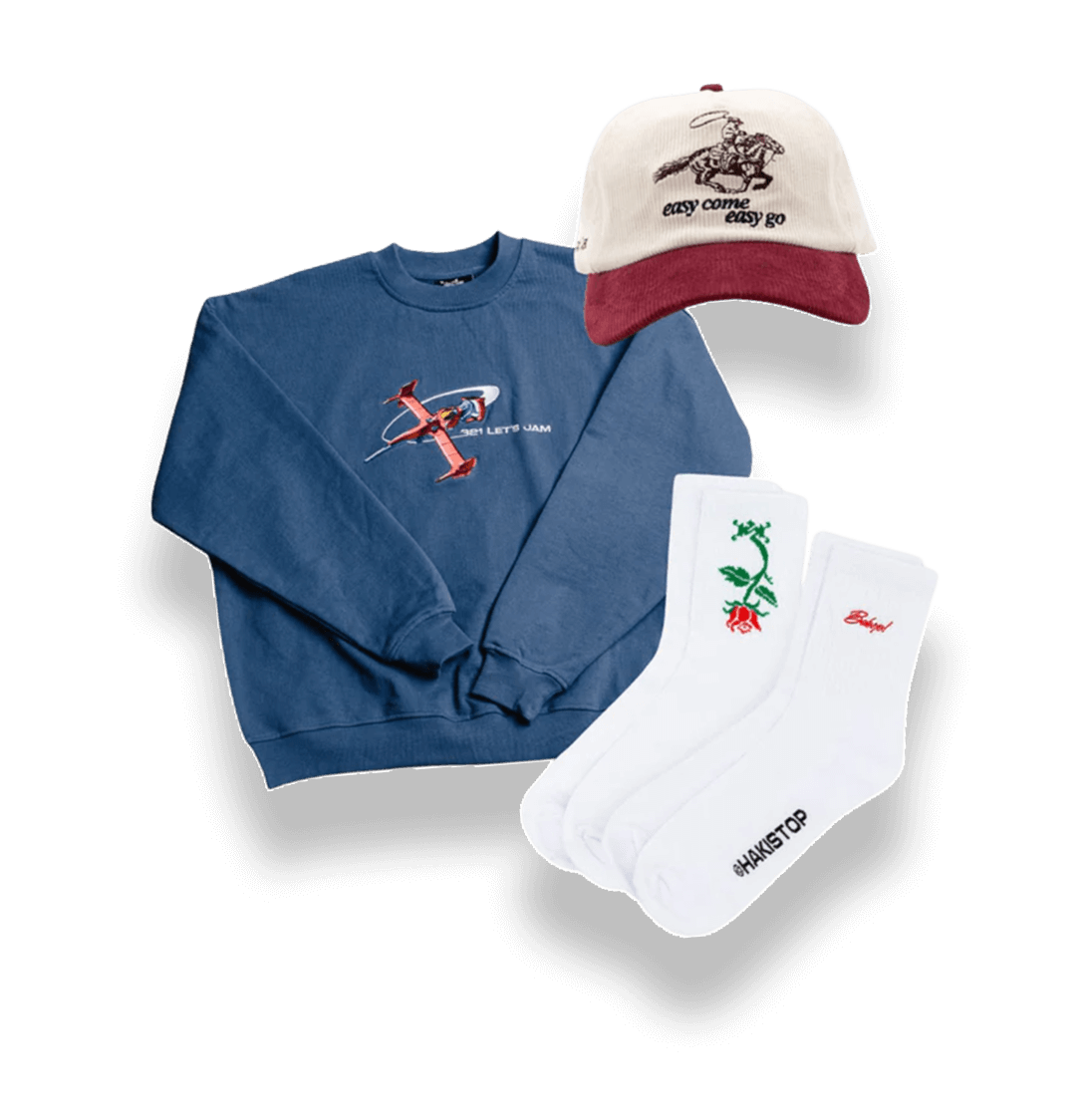Blue sweatshirt, white socks, and a beige-red cap with text and graphics.