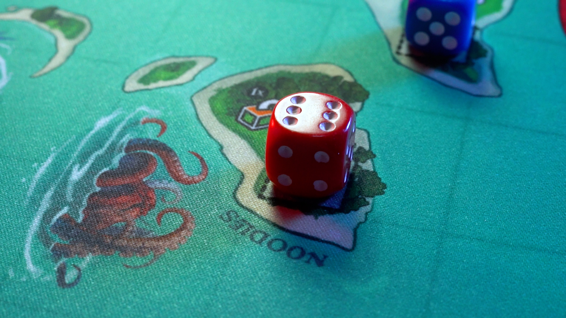 A red die and a blue die on a green board game map featuring islands and a sea monster.