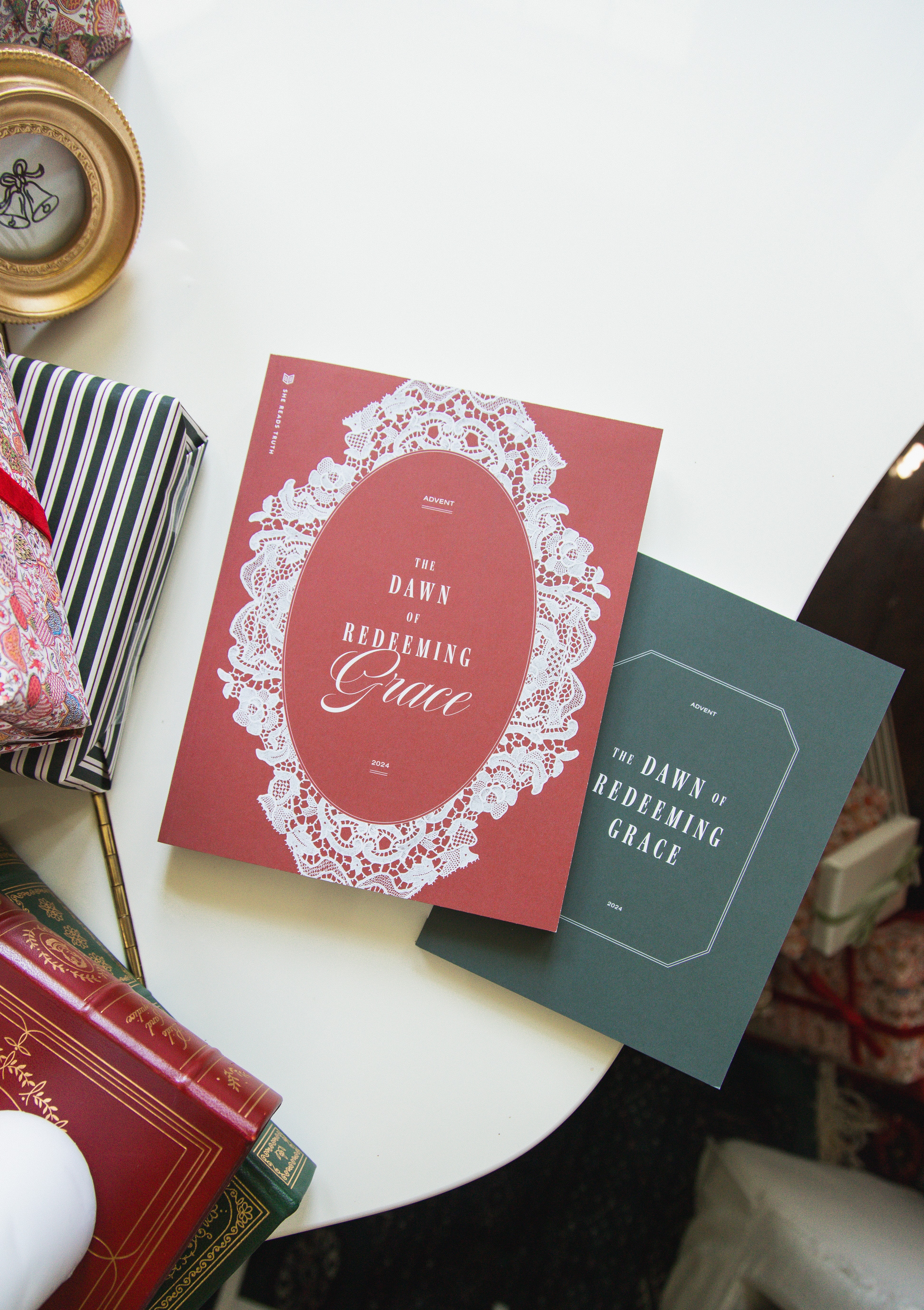 Two books titled 'The Dawn of Redeeming Grace' on a white table.