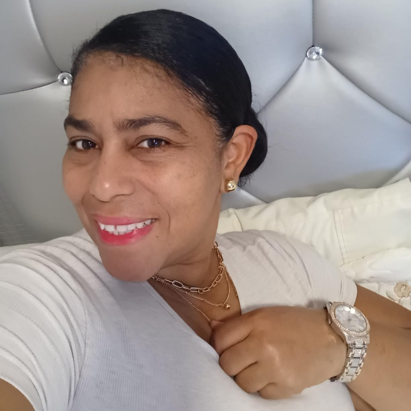 Smiling person holding a Heriyana skincare product.