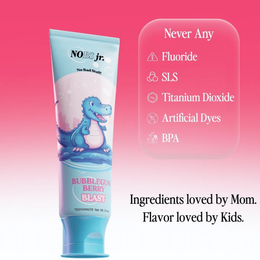 A tube of NOBS jr. kids' toothpaste with a cartoon dinosaur against a pink background with text.