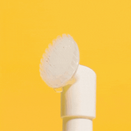 White showerhead spraying water against a bright yellow background.