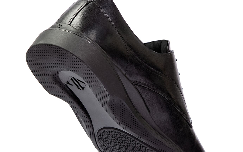 Close-up of a black leather shoe with a textured sole.
