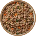 A circular bowl filled with a mixture of ground meat, diced carrots, and chopped green herbs.