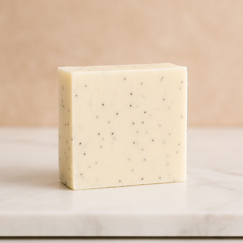 Beige soap bar with small black specks on a marble surface.