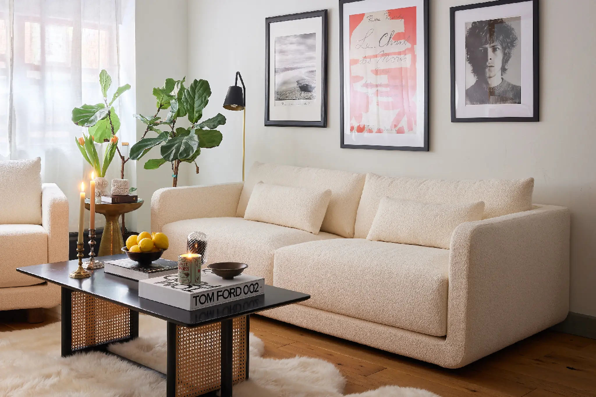 Cozy living room with beige sofa, coffee table, plants, and framed art on the wall.