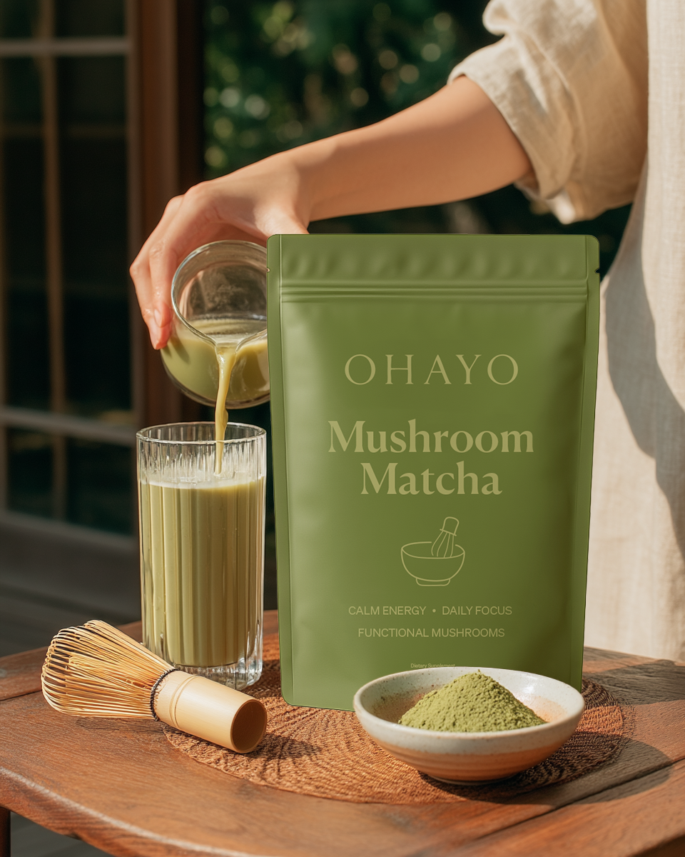 Person pouring green drink into glass beside mushroom matcha package.
