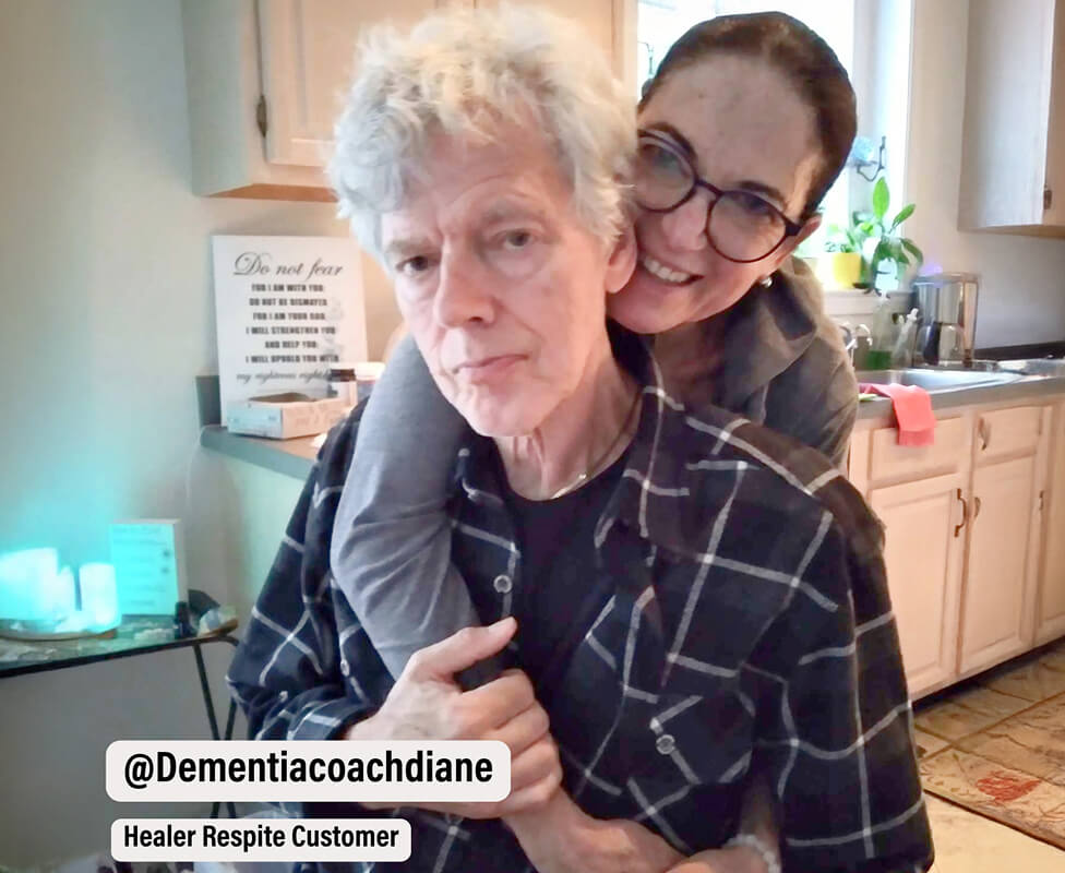 Two people in a kitchen, one hugging the other from behind.