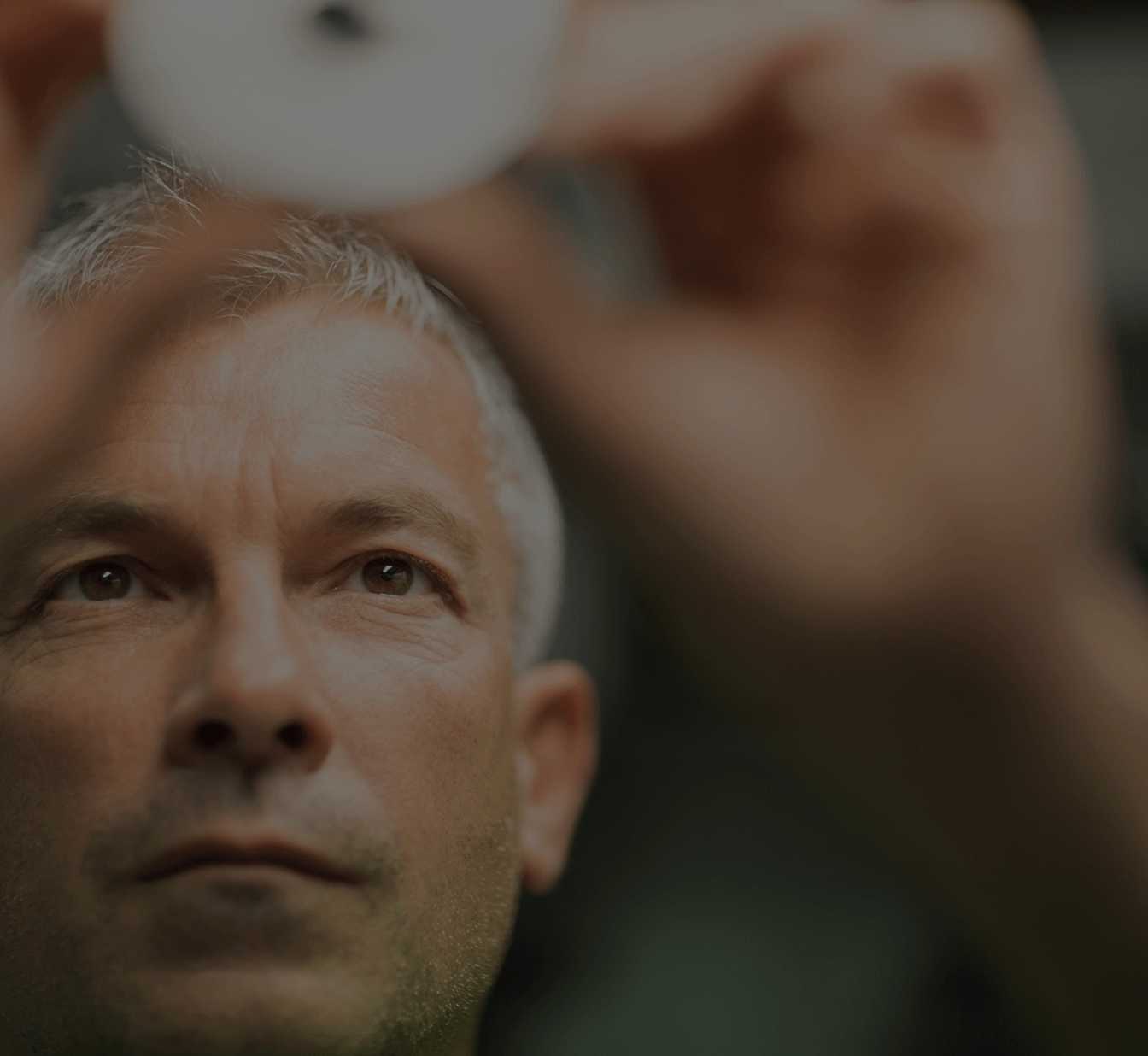 Man looking closely at an object in his hand.