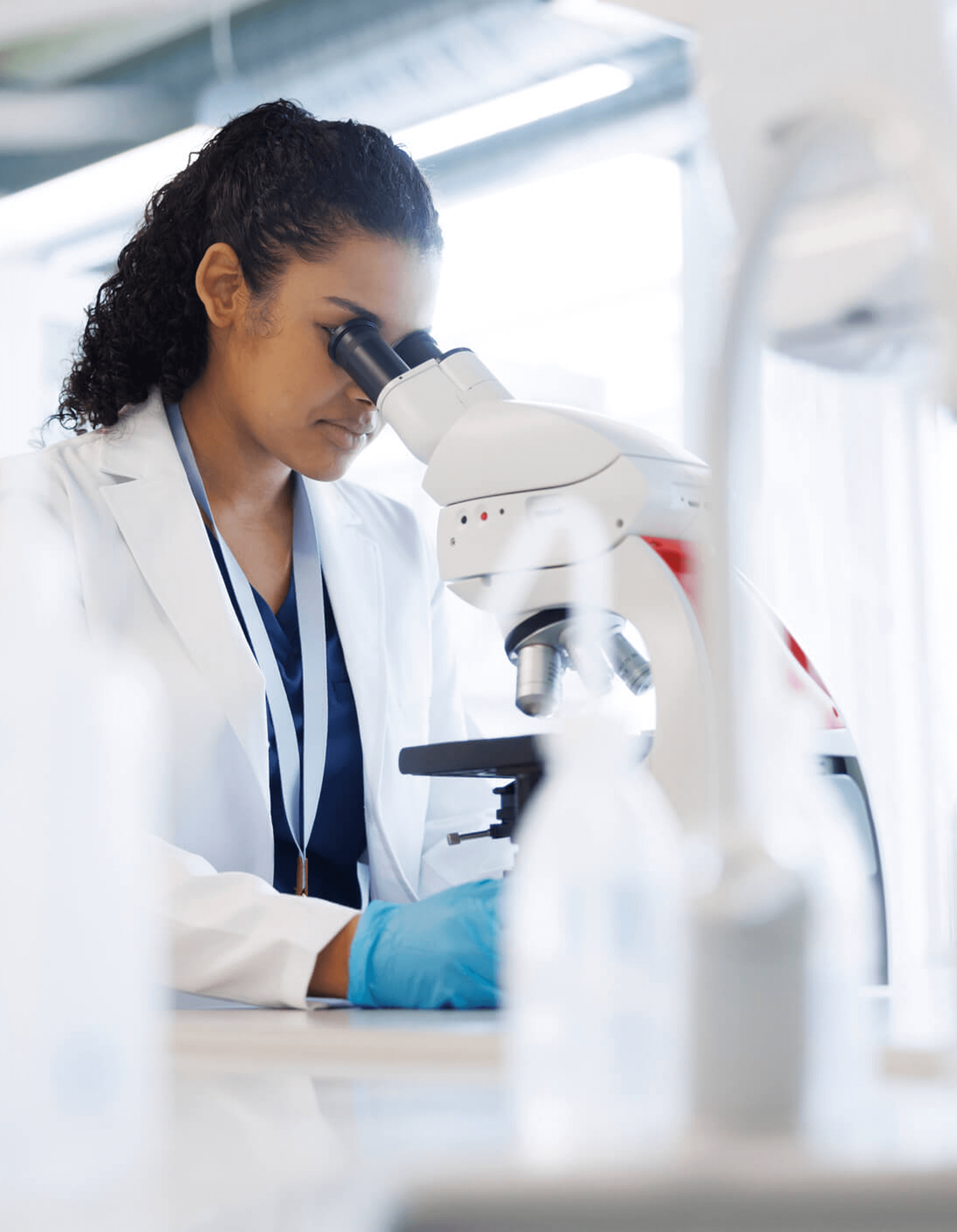 Scientist examining a sample under a microscope in a laboratory.