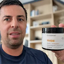 Person holding a jar labeled 'COGNIX RISE' in a room with shelves.
