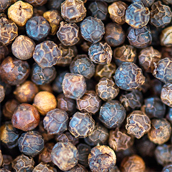 Close-up of black pepper in various shades of brown and black.