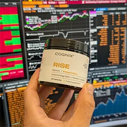 Hand holding a jar labeled 'RISE' in front of stock market screens.