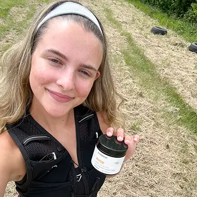 Young Woman in workout gear holding Cognix RISE bottle