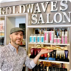 Person in a salon displaying hair products on shelves.