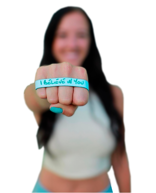 Person showing fist with 'I BELIEVE IN YOU' written on a band.
