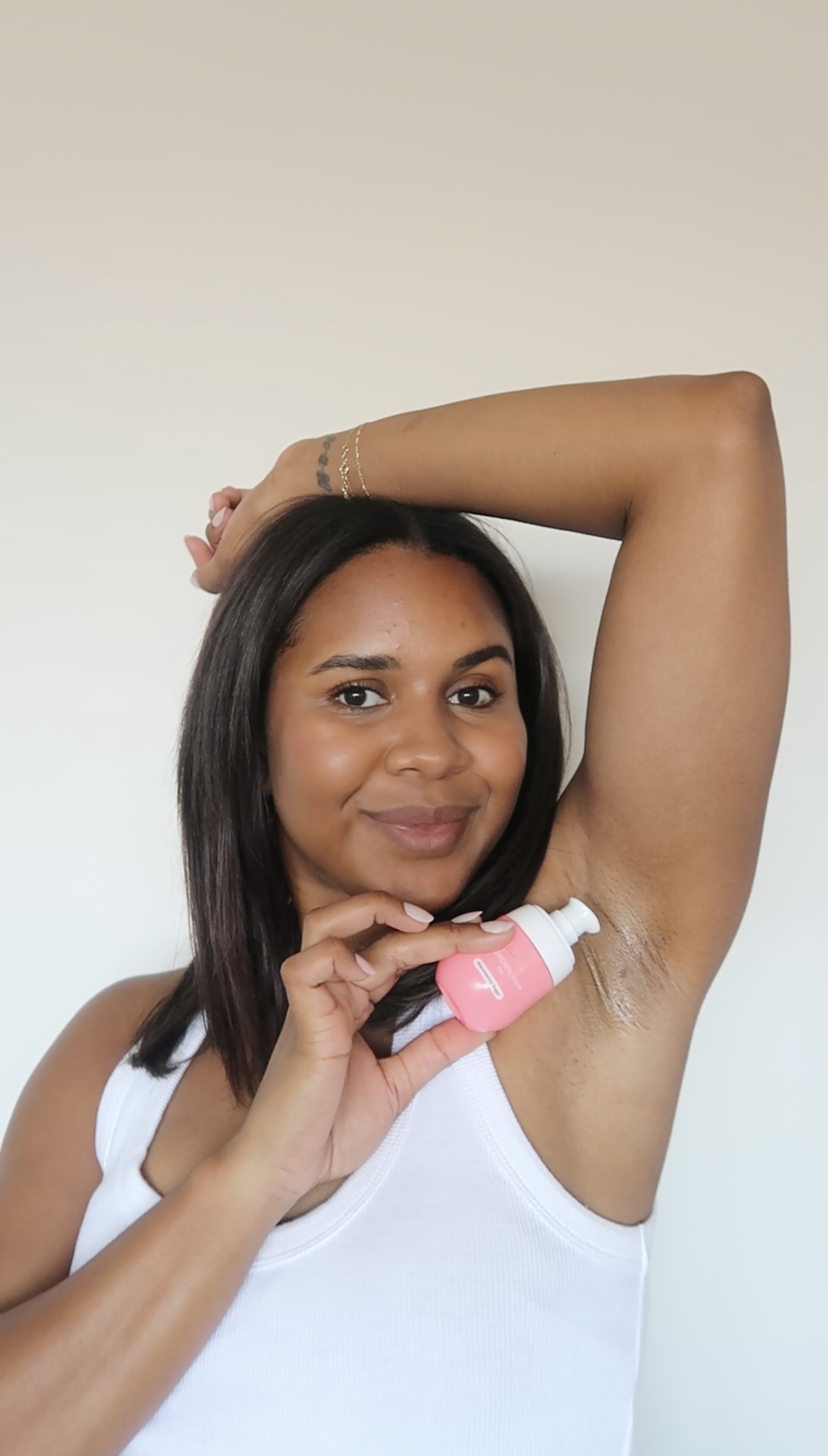 Person applying deodorant to underarm with a smile.