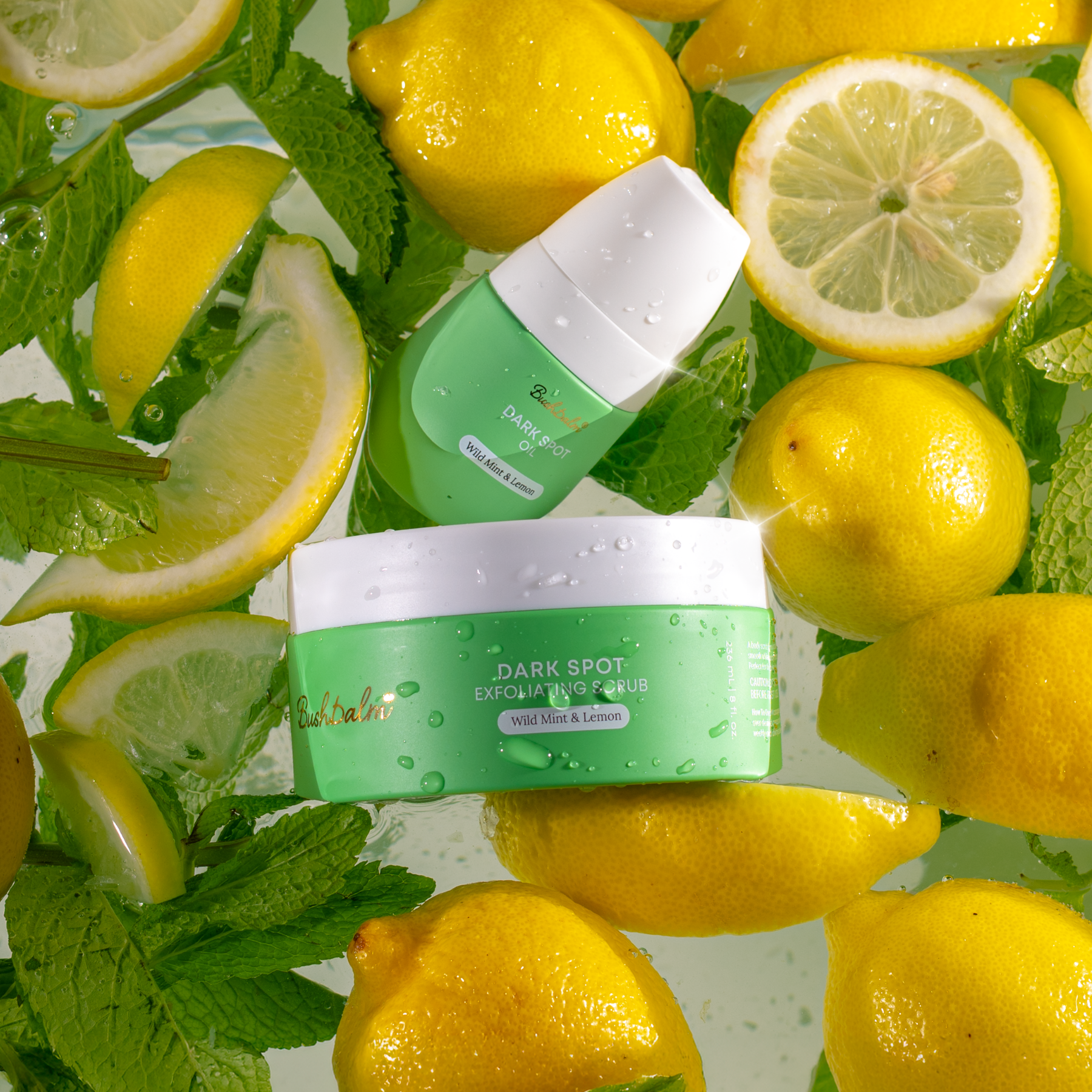 Two green cosmetic containers float in water surrounded by fresh lemons and mint leaves.