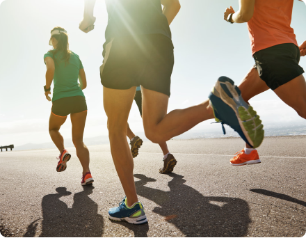 Group of people running on a sunny road.