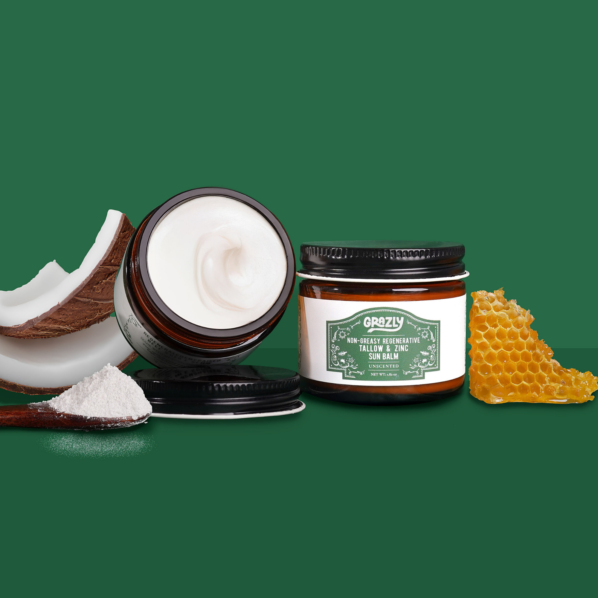 Jars of sun balm with coconut, powder, and honeycomb on green background.