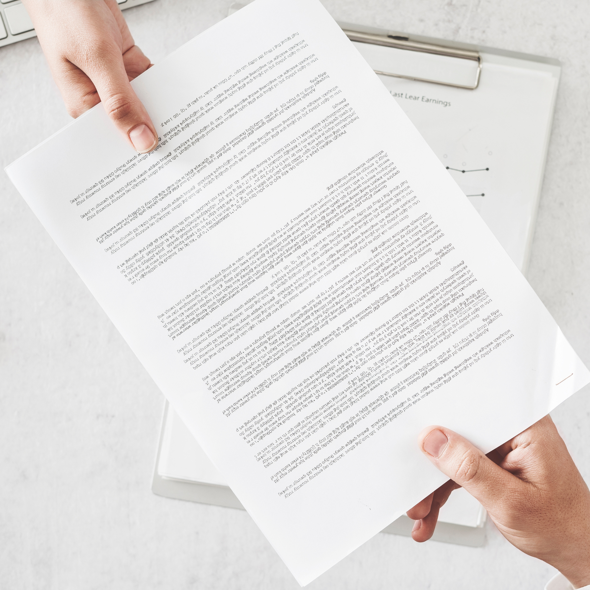 Two hands exchanging a printed document over a clipboard.